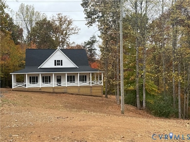 Back of property with a porch and roof with shingles