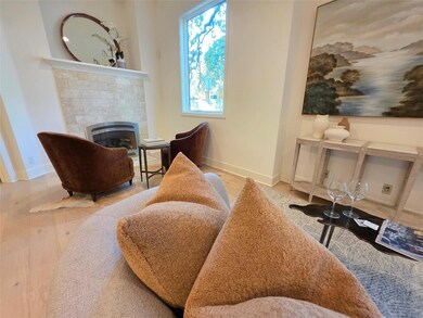 Living area with a tiled fireplace, baseboards, a