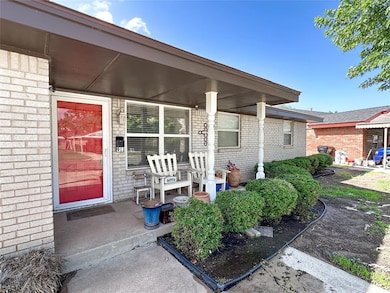 View of exterior entry with covered porch and brick siding