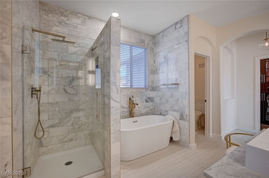 Primary Bathroom with a freestanding tub, a stall