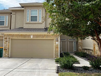 Multi unit property featuring stone siding, a gar