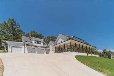 View of front of home with a porch, a front yard, and driveway