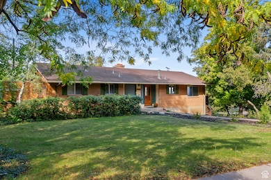 Single story home with brick siding, a front lawn, and a chimney