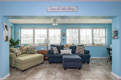 Living area with ceiling fan and baseboards