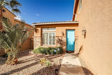 View of exterior entry with stucco siding, stone siding, and a tiled roof