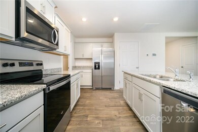 Elegant Kitchen with White Cabinets, Granite Countertops and Stainless Steel Appliances