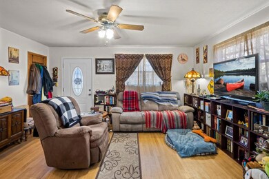 Living room with ceiling fan and wood finished fl