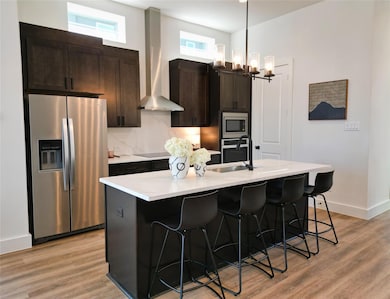 Kitchen with sink, wall chimney range hood, applia