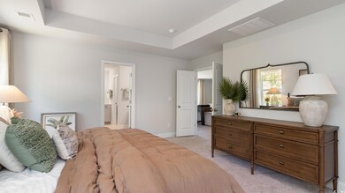 Bedroom featuring light carpet, connected bathroom