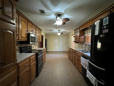 Kitchen with black electric range oven, ceiling fa