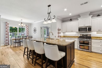 Kitchen is fully equipped with stainless steel appliances, double oven range, island with sink and storage on either side, room for chairs or stools