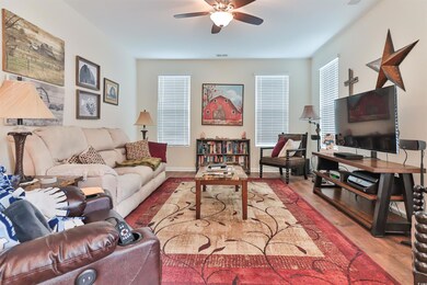 Living room with ceiling fan and wood-type floorin