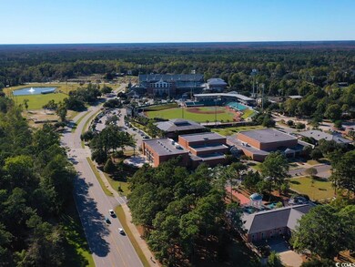 Aerial view of property's location featuring a forest and a nearby body of water