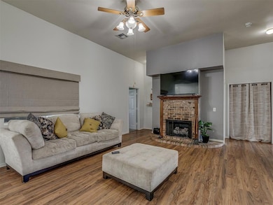 Living area featuring ceiling fan, a fireplace, and wood finished floors