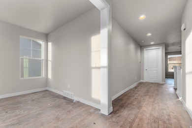 Hallway featuring light wood finished floors and recessed lighting