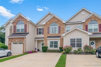 View of property featuring brick siding, driveway,