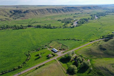 Looking northeast across buildings, hayfields, and
