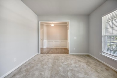 Unfurnished room with light carpet and baseboards