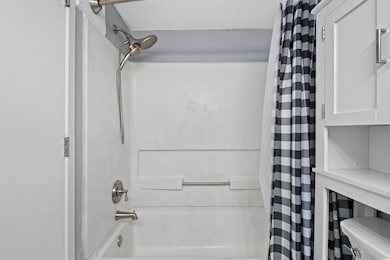 Bathroom featuring shower / tub combo and toilet