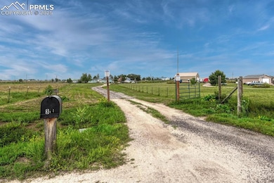 View of dirt / gravel road featuring a view of rural / pastoral area and a gated entry