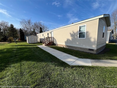 View of home's exterior featuring a storage shed and a lawn