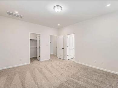 Unfurnished bedroom featuring light carpet, reces