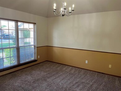Carpeted empty room featuring a notable chandelier