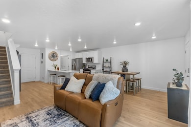 Open concept living area featuring stairs, light wood-style floors, and recessed lighting