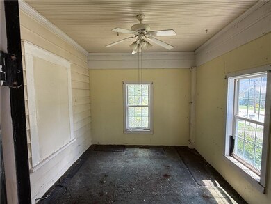 Empty room featuring crown molding and ceiling fan