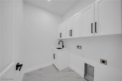 Clothes washing area with marble finish floor, bas