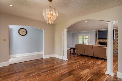 View from front Dining room corner to Living room, fireplace and doors to screened in Patio.