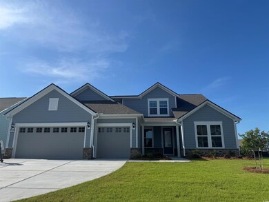 Craftsman-style house with driveway, a front yard, an attached garage, a shingled roof, and stone siding