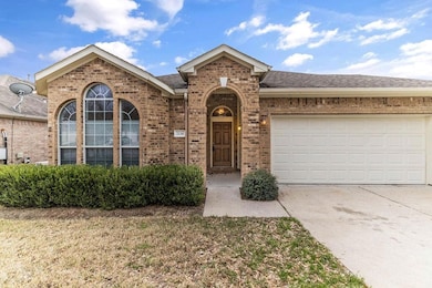 View of front of house featuring brick siding, concrete driveway, an attached garage, a shingled roof, and a front yard
