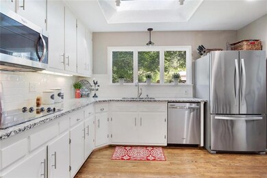 Granite and large window enhance the kitchen.