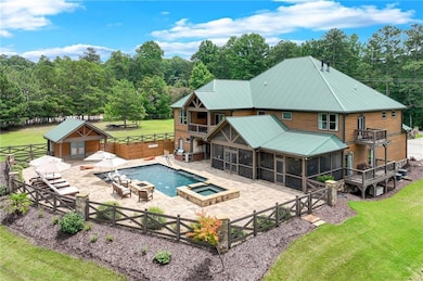 View of pool featuring a sunroom, a patio, a fenced backyard, a pool with connected hot tub, and a fire pit