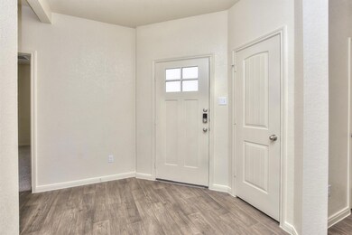 Foyer with baseboards and wood finished floors