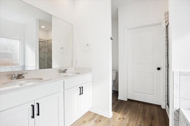 Bathroom with double vanity, a sink, and wood fin