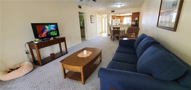 Living room with ceiling fan and light carpet