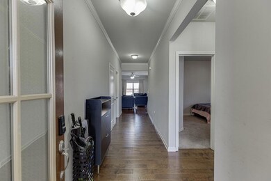 Corridor with crown molding and dark wood-type flooring