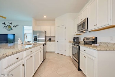 Kitchen featuring light stone countertops, stainle