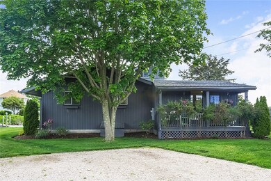 Front of home with a covered porch and shady maple