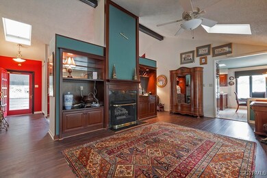 Living room featuring ceiling fan, dark wood-type