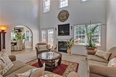 High ceilings and lots of windows in the open family room with a gas fireplace. Arched entry into the eat-in kitchen.