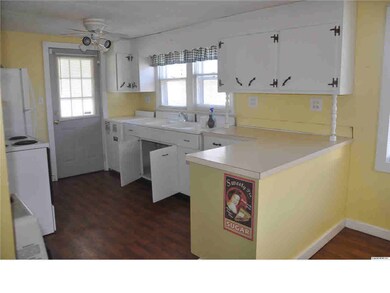 Neat kitchen with stove and refrigerator, large pantry, and the door goes out to a covered porch