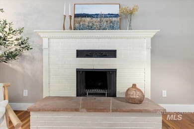 Detailed view of wood finished floors and a brick fireplace