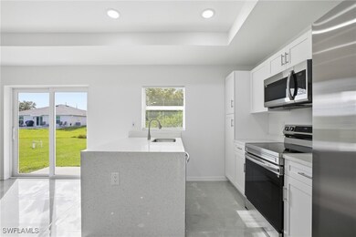Kitchen featuring stainless steel appliances, light stone counters, white cabinets, recessed lighting, and a peninsula