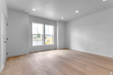 Unfurnished room featuring light wood finished floors, a textured ceiling, and recessed lighting