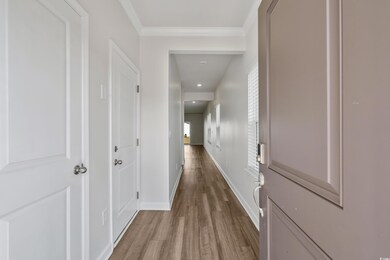 Corridor with ornamental molding, baseboards, and 
