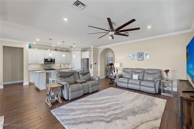 Living room featuring crown molding, dark hardwood