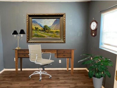 Study has luxury vinyl floors, with view of backyard.